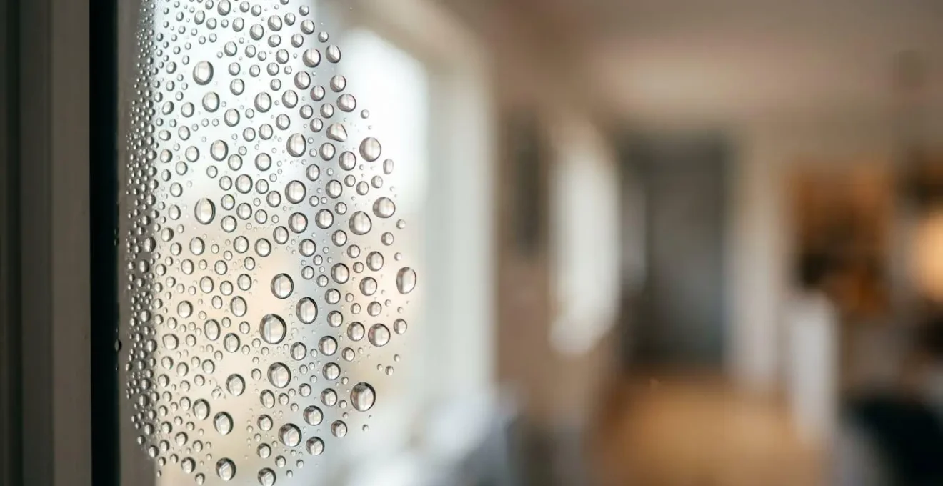 Gouttelettes de condensation sur une surface vitrée illustrant les problèmes d'humidité