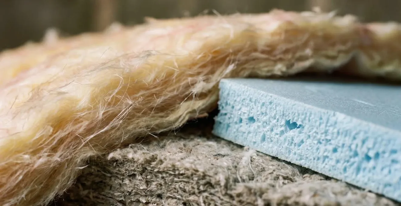 Gros plan macro sur des échantillons de matériaux d'isolation posés sur une surface neutre avec textures visibles