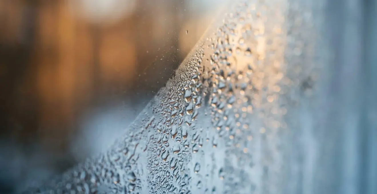 Gros plan détaillé sur la texture d'une vitre moderne montrant la formation de condensation